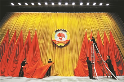 工作人员在调整主席台立体会徽及旗帜本报融媒体直播间亮相政协会场