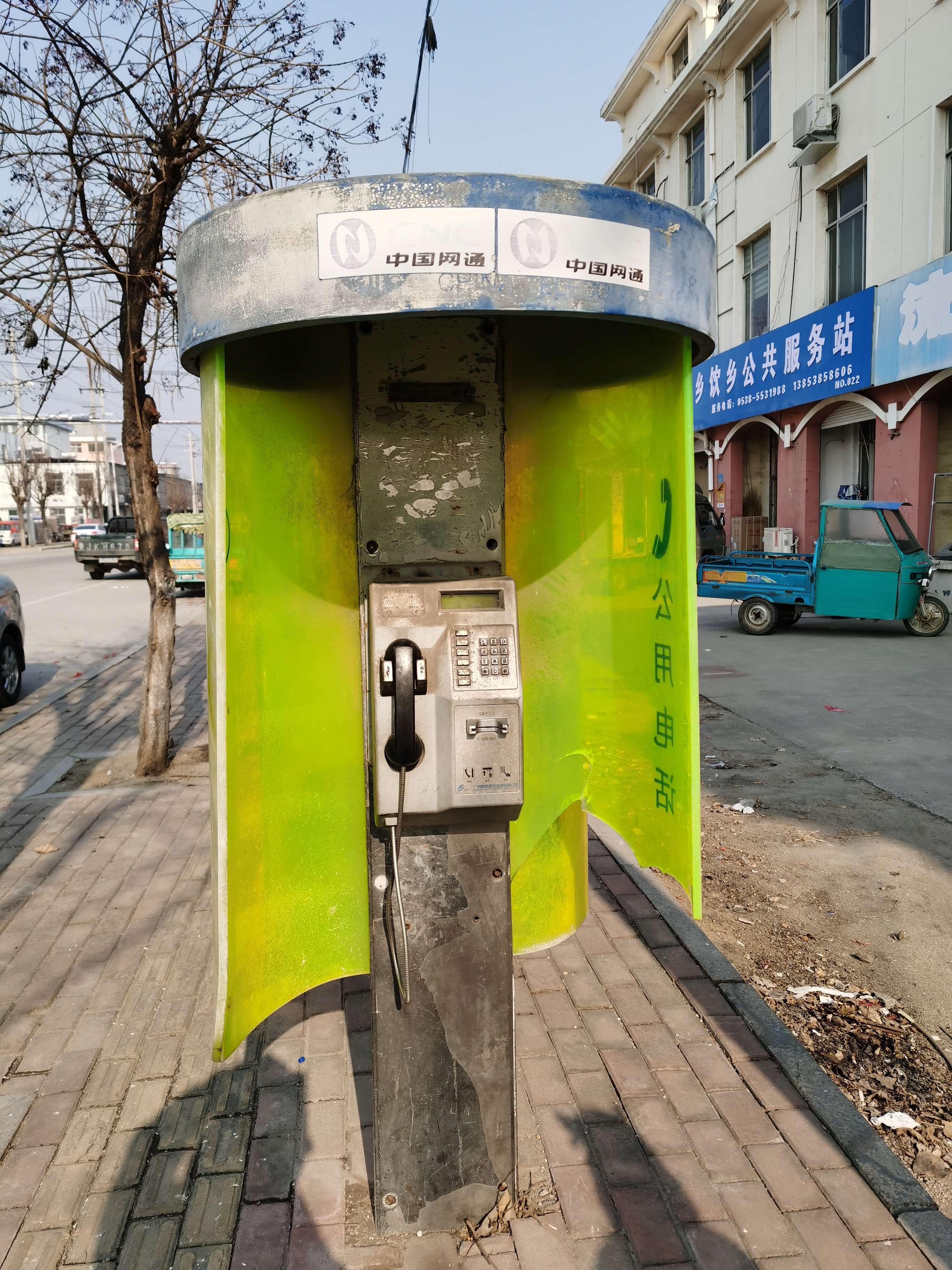 在泰安市宁阳县乡饮乡街头一个废弃的旧电话亭引起了小朋友的好奇